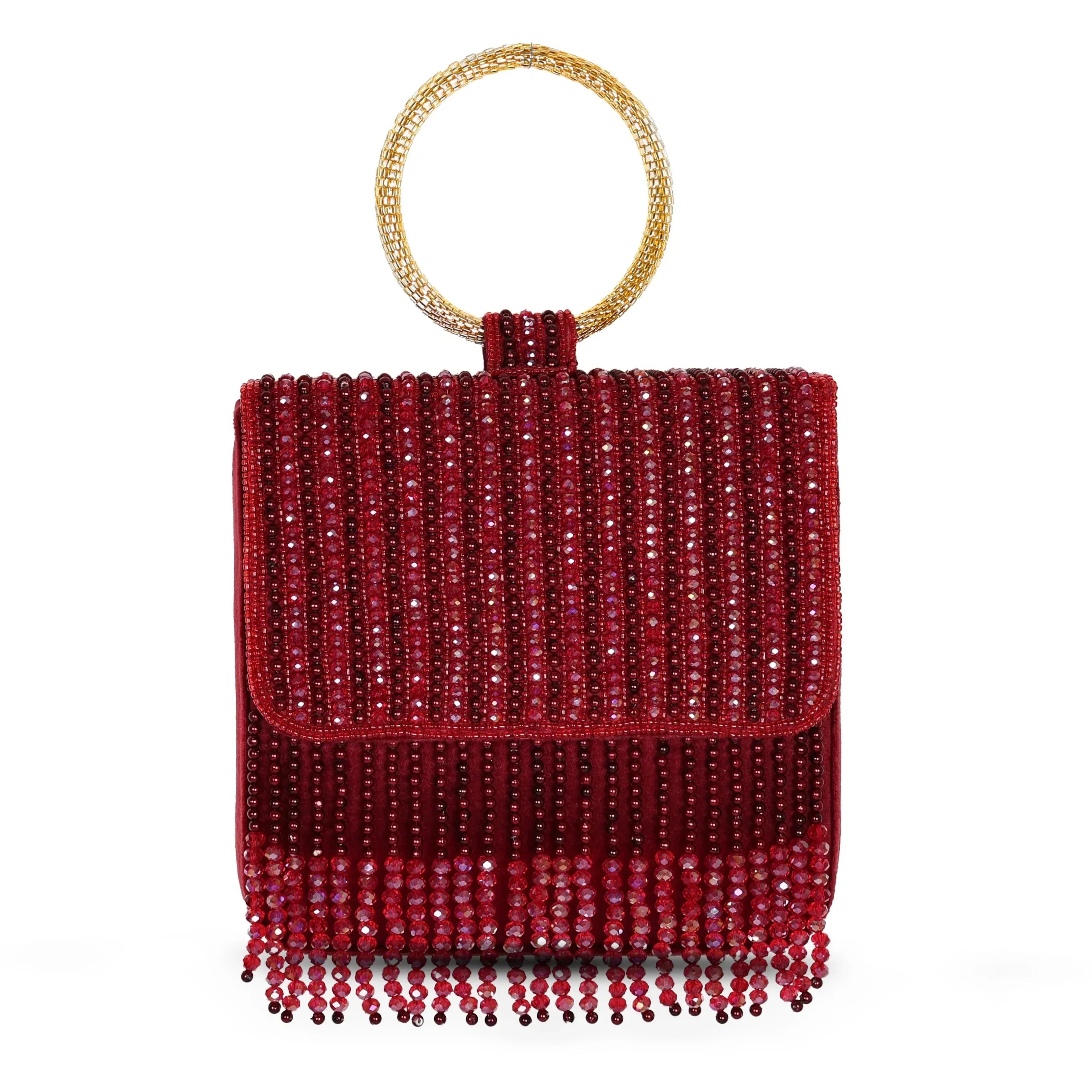 A mehroon (maroon) colored embroidered clutch with a round golden handle and beaded fringe.