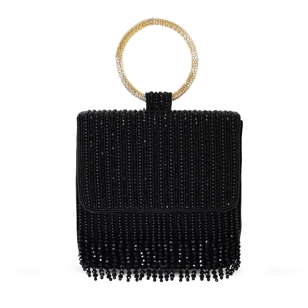 A black embroidered clutch with a golden handle and fringes, closed with a snap button.