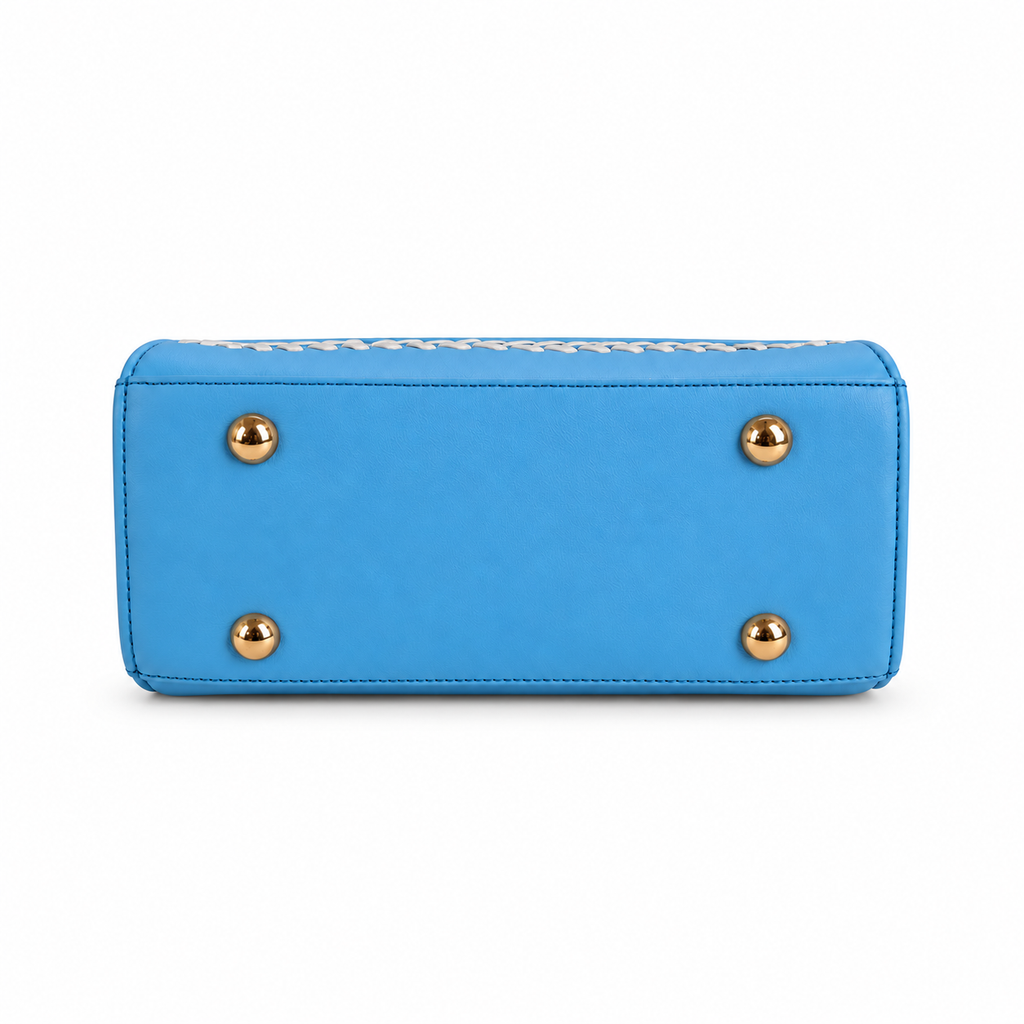 The bottom view of a bright blue leather clutch or wallet featuring four gold-tone metal studs on the front face and a white woven trim along the top edge, set against a plain white background.