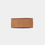 Bottom base of brown snake-textured handbag featuring four protective metal studs