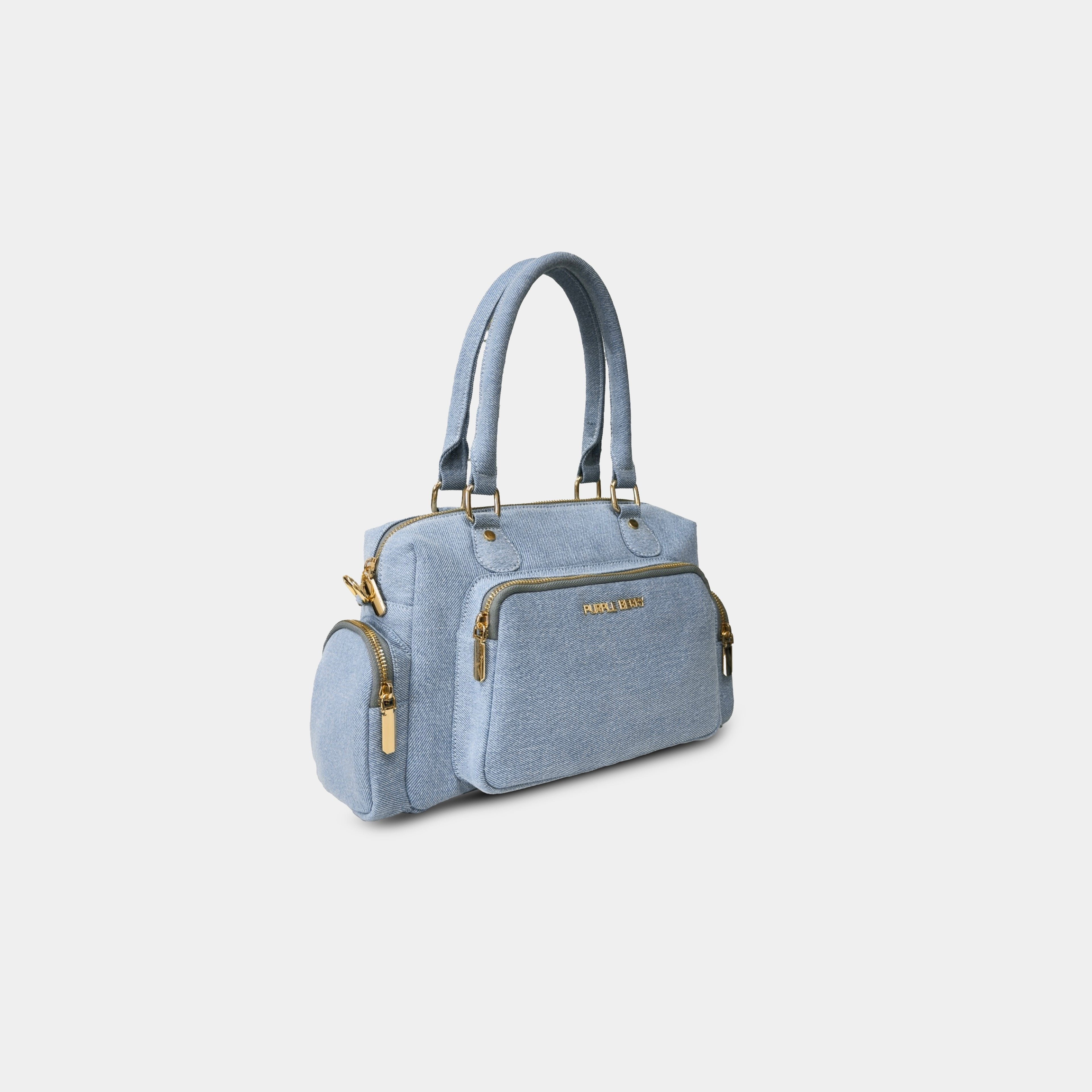 Angled view of light blue Frida denim sling bag with side zipper pockets