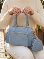 Model carrying light blue Frida denim sling bag with matching coin pouch
