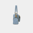 Side profile of light blue Frida denim sling bag highlighting side zipper pocket