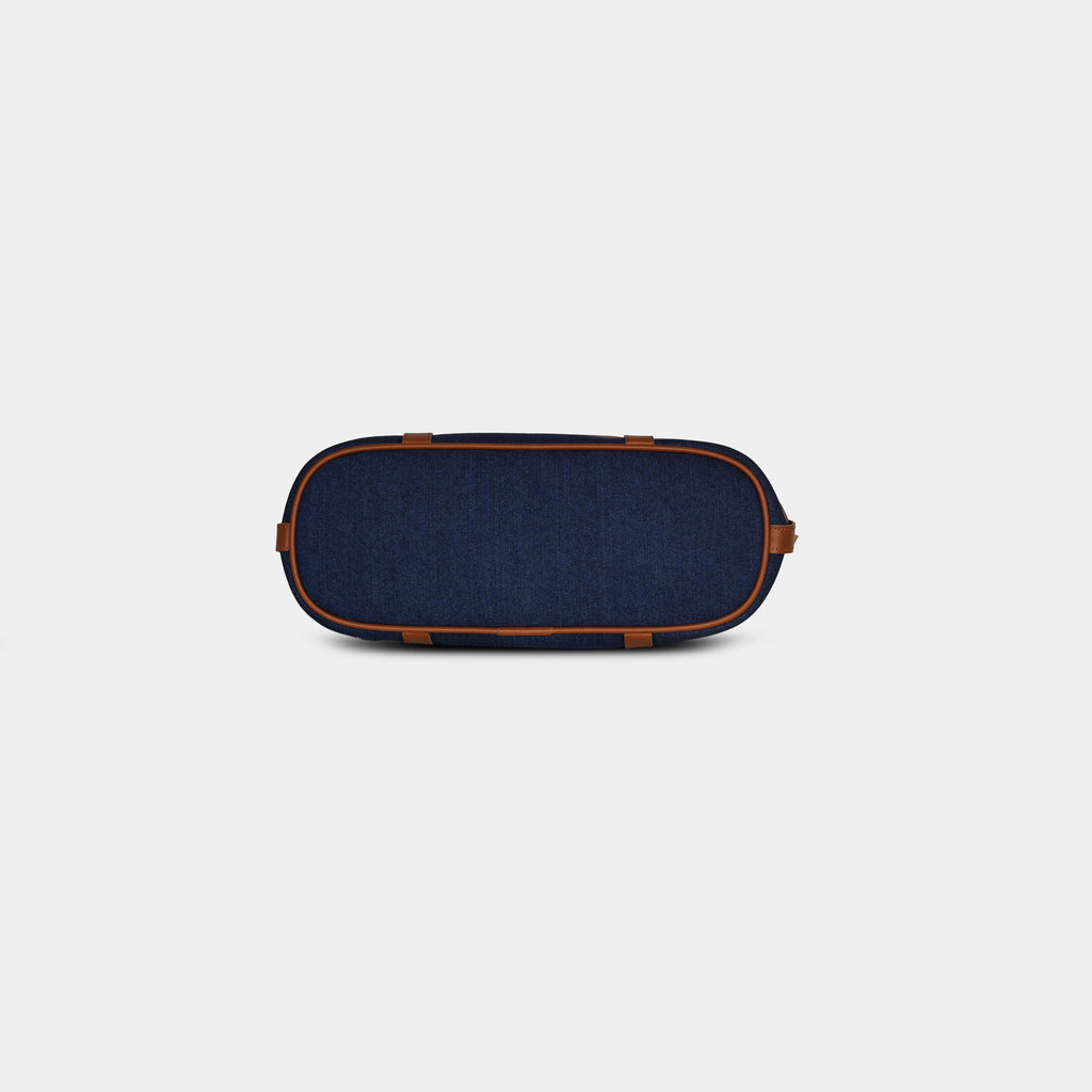 Bottom view of dark blue Harper denim handbag featuring four protective metal base studs
