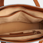 Interior compartment of light blue Harper denim handbag with two slip pockets and secure zipper pocket