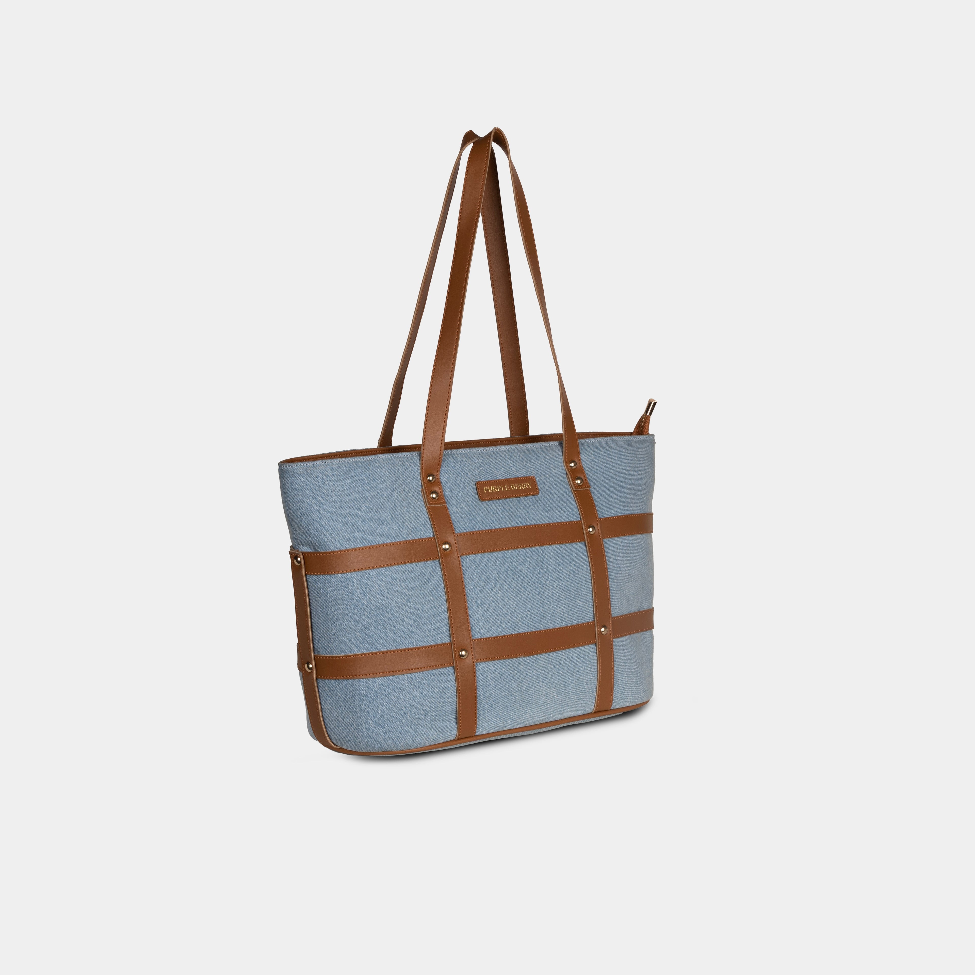 Side view of light blue Harper denim tote with faux leather grid straps and structured body