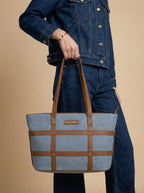 Women carrying  light blue harper grid strap denim handbag at her wrist level