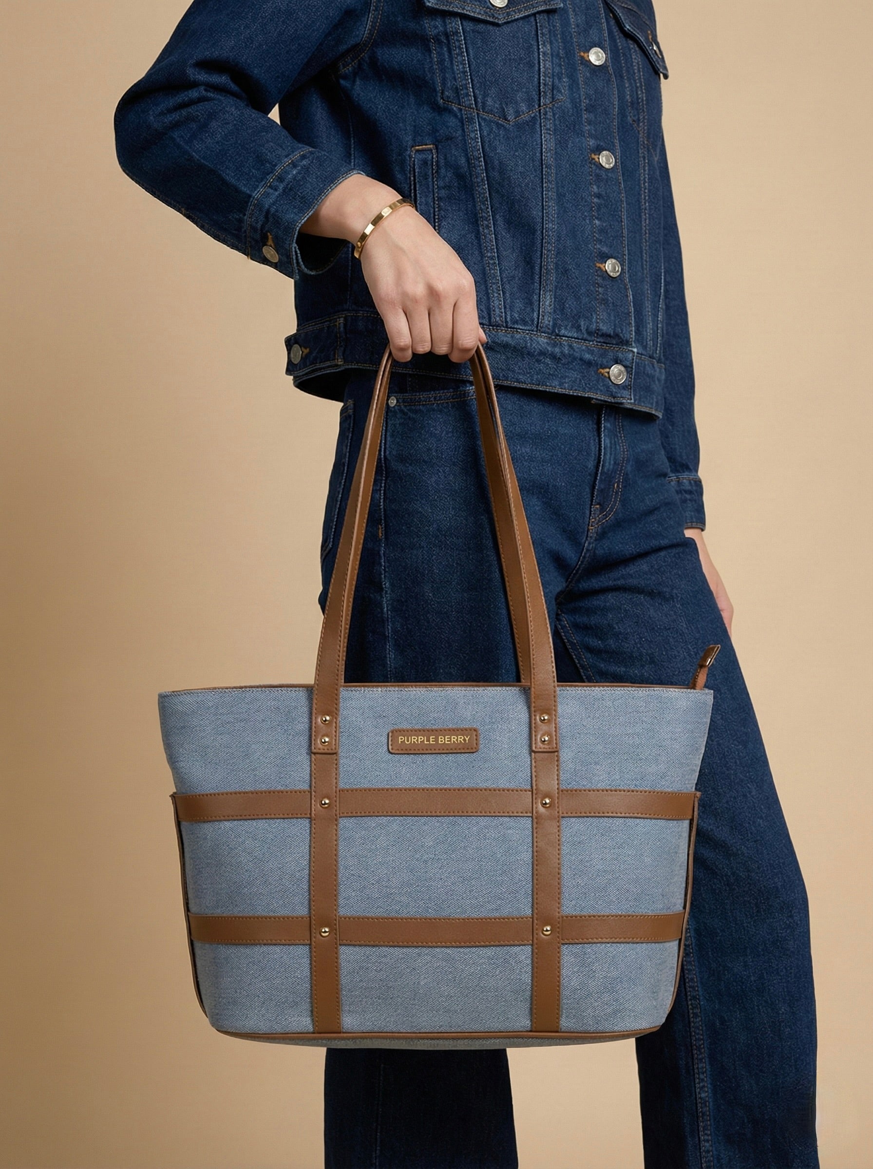 Women carrying  light blue harper grid strap denim handbag at her wrist level