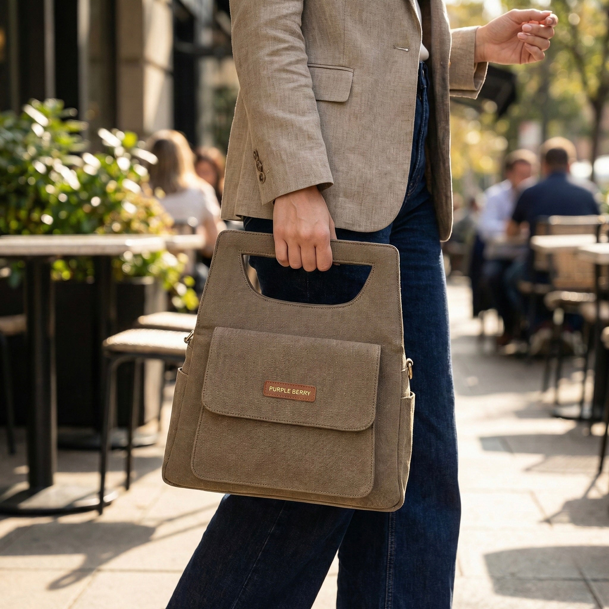 Woman carrying brown Hera denim handbag with modern top handle