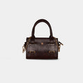 Close-up of detachable gold chain strap on dark brown Lumière mini party bag