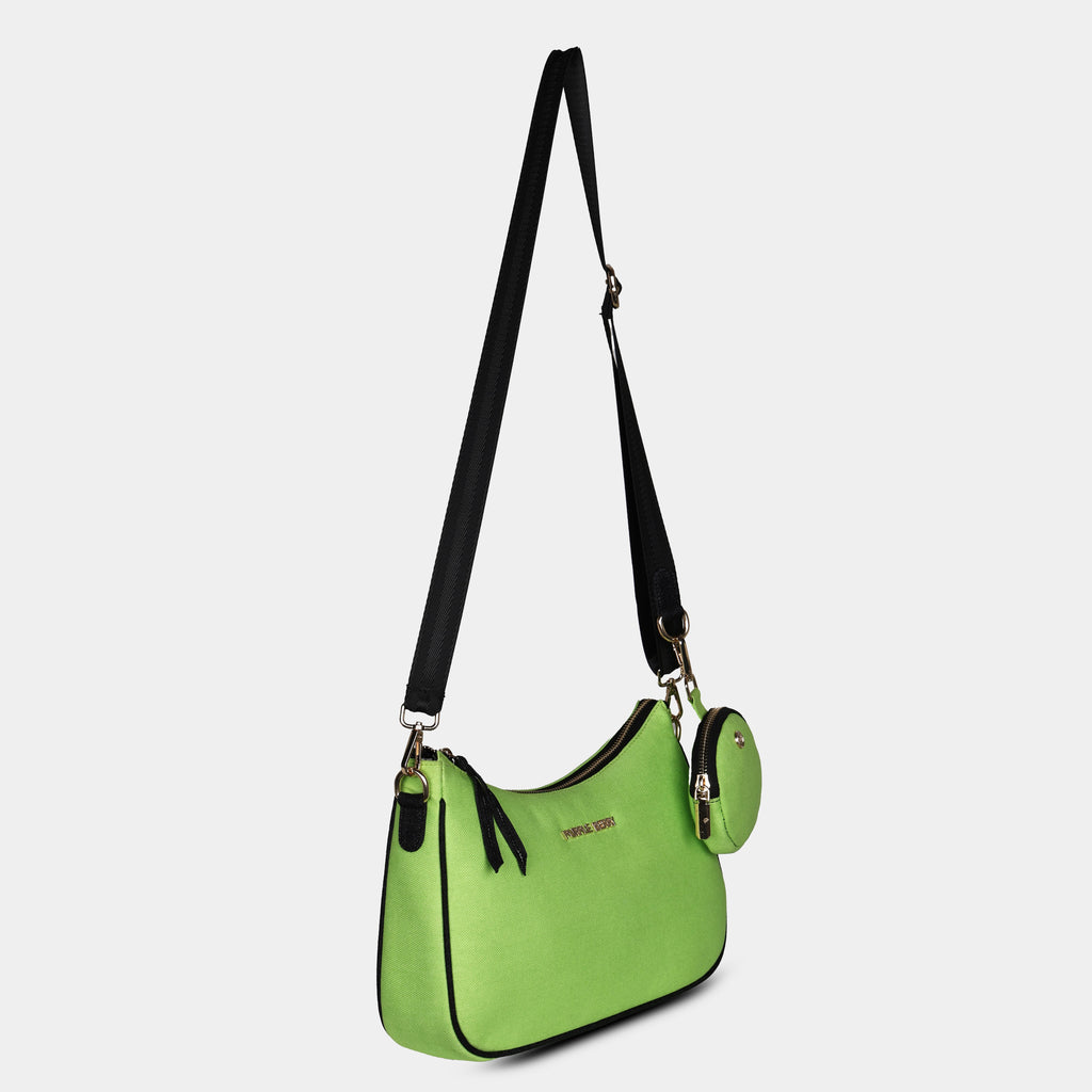 Side angle of green Bili denim sling bag highlighting slim curved silhouette