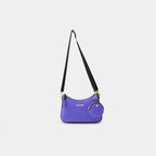 Front hanging view of purple Bili denim sling bag highlighting curved shape and gold hardware