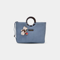 Light blue Dima denim office tote bag with round ring handles and teddy bear charm attached