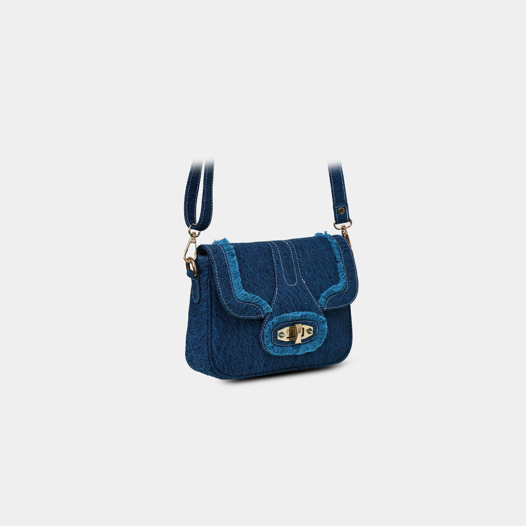 Angled front view of Purpleberry Luna blue denim sling bag with white contrast stitching