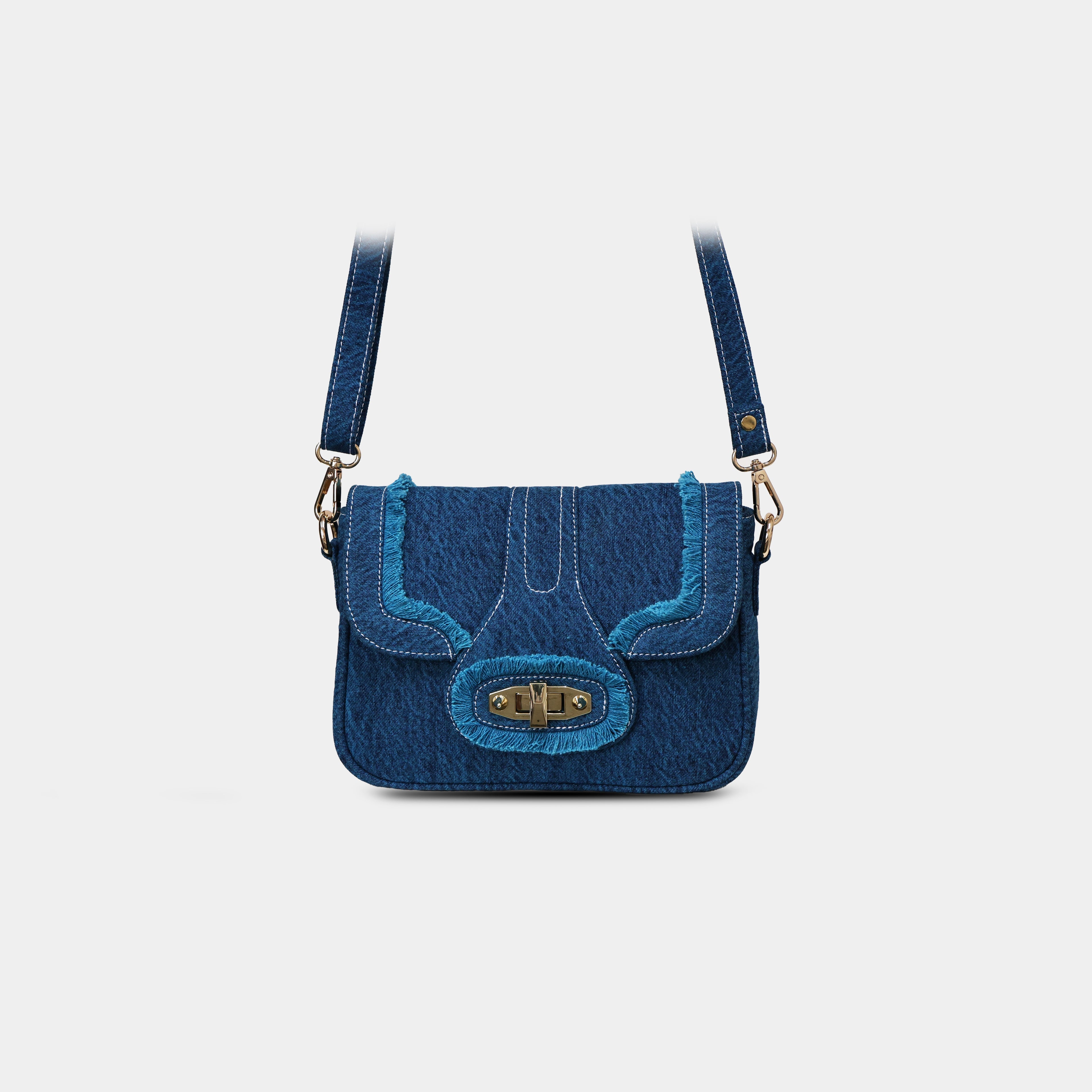 Close up of fringe detailing and rotating lock on Purpleberry Luna blue denim sling