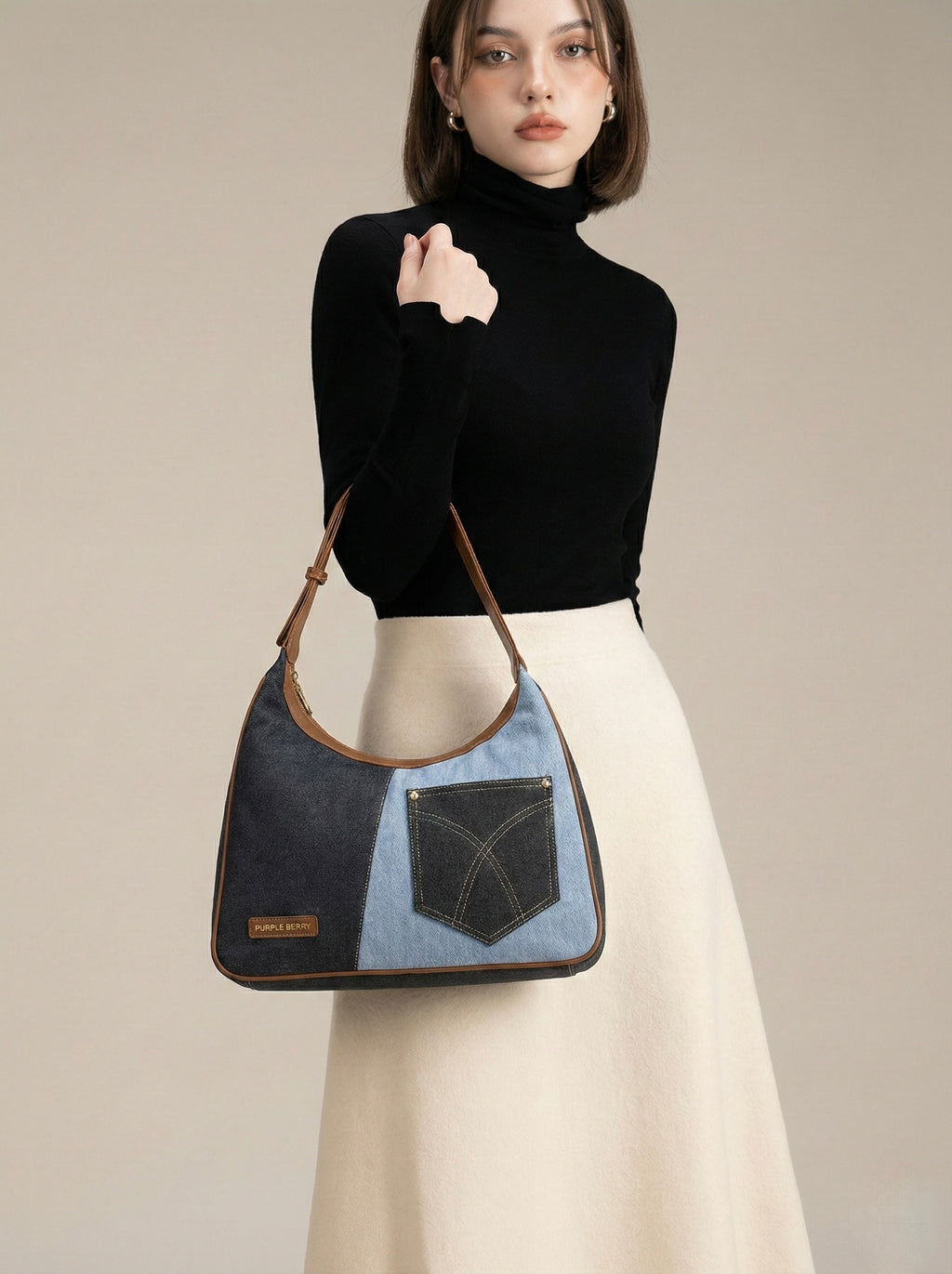 Woman holding a denim Shoulder bag against a neutral background

