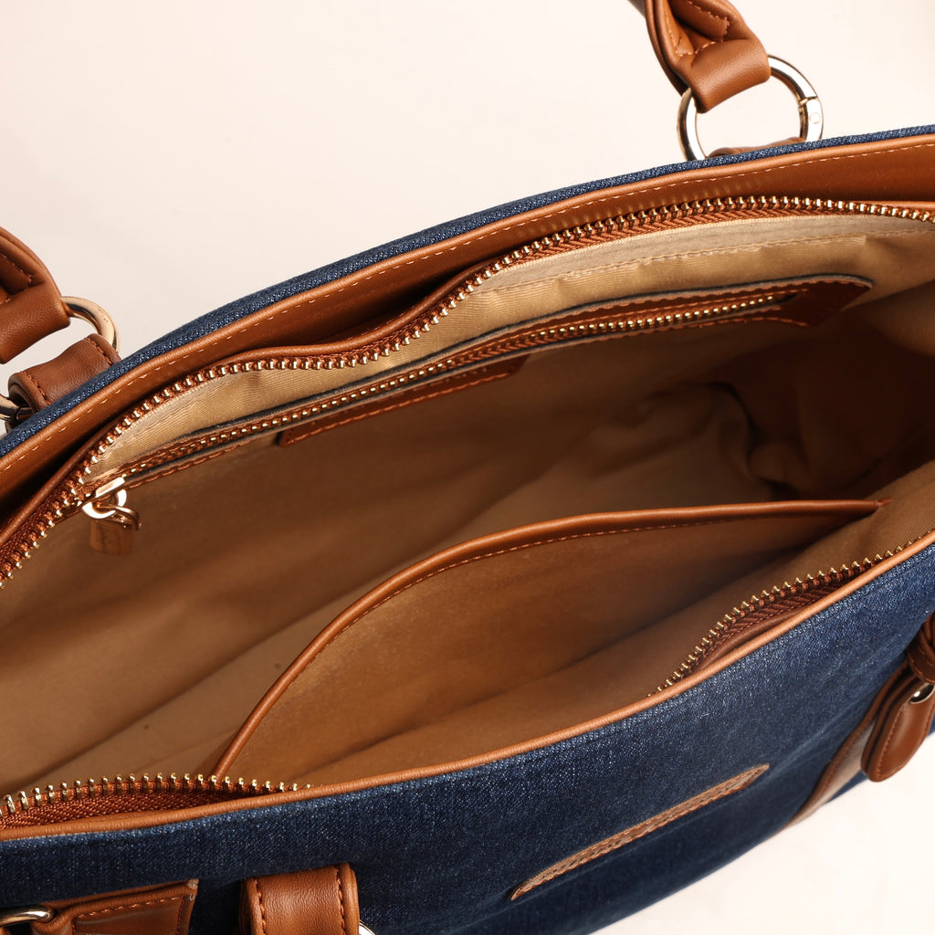 Spacious interior of deep navy denim handbag with zipper pocket and slip pocket compartments