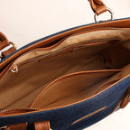 Spacious interior of deep navy denim handbag with zipper pocket and slip pocket compartments