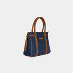 Side angle view of Purpleberry deep navy denim handbag showing structured shape and side tassels